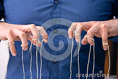 Manipulating Marionette Puppet Strings By Hand Stock Photo