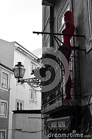 Maniqin on the balcony. Old Lisbon street photo. Art. Red black and white. Lantern. Building Windows. Emotions. Beautiful Editorial Stock Photo