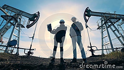 Manliga teknikerer talar, medan stå mellan bränsle som pumpar maskiner Energi olja, gas, bränsle som pumpar riggen stock video Manliga teknikerer talar, medan stå mellan bränsle som pumpar maskiner Energi olja, gas, bränsle som pumpar riggen stock video