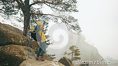 Mann in der gelben Jacke klettert die Felsen in den Winterbergen Mann in der gelben Jacke klettert die Felsen in den Winterbergen