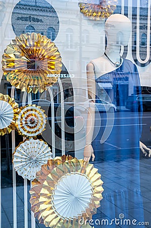 A mannequin in a blue dress in a New Year's showcase with gold large circles Editorial Stock Photo