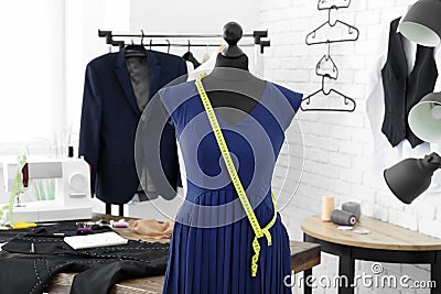 Mannequin with custom tailored dress and measuring tape in atelier Stock Photo