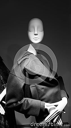 Mannequin wearing a luxury coat seen through the window Stock Photo