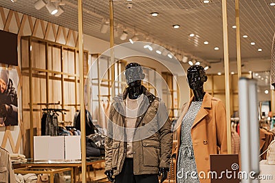 Mannequins in fashion shopfron. Boutique display window with mannequins in fashionable dresses Editorial Stock Photo
