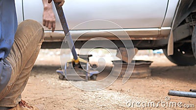 Manos de mecánico utilizando un gato para levantar el camión y reparar el brazo de control de hueso y sustituir la rueda delanter metrajes Manos de mecánico utilizando un gato para levantar el camión y reparar el brazo de control de hueso y sustituir la rueda delanter metrajes