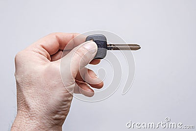 Mans hand with blank key on a grey background Stock Photo