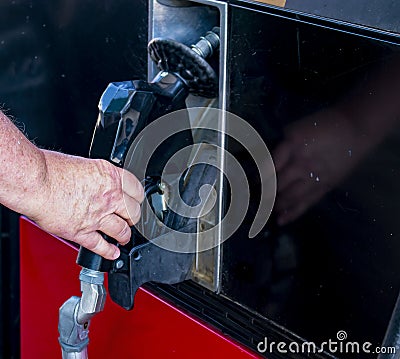 Mans hand grasping nozzle of gas pump to remove it to fill up vehicle with gas Stock Photo
