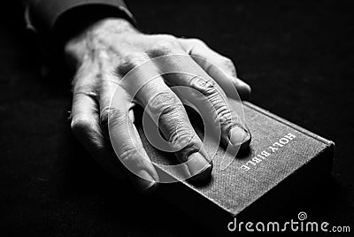 A mans hand on the Holy Bible. Stock Photo