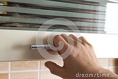 Mans hand open the kitchen cupboard doors, close up Stock Photo