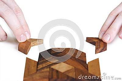 Mans hands assembling wooden square puzzle Stock Photo