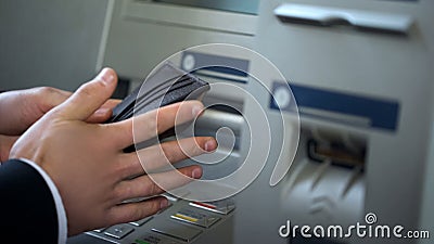 Mans hands putting euros in wallet, cash withdrawn from ATM, travelling abroad Stock Photo