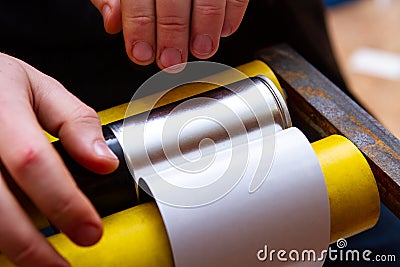 Manual application of stickers on aerosol cans with automotive and other chemical composition Stock Photo