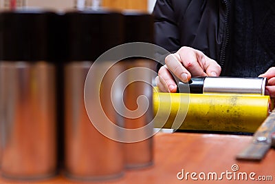 Manual application of stickers on aerosol cans with automotive and other chemical composition Stock Photo