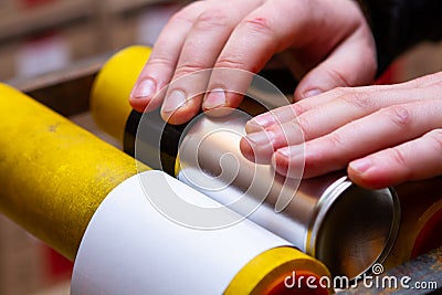 Manual application of stickers on aerosol cans with automotive and other chemical composition Stock Photo