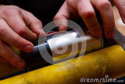 Manual application of stickers on aerosol cans with automotive and other chemical composition Stock Photo