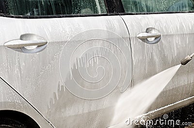 Manual car washing cleaning with foam and pressured water at service station Stock Photo