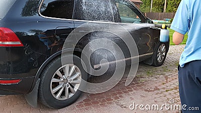 Manual car washing with high pressure power washer, cleaning dirty auto outside Stock Photo