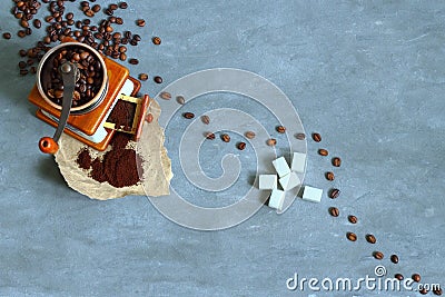 Manual coffee grinder, beans, ground coffee and sugar on a gray concrete background, top view Stock Photo