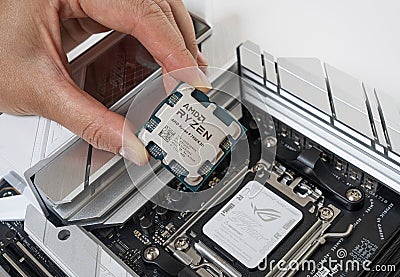 Manual installation of the AMD Ryzen 9 7950X3D processor into the motherboard. Editorial Stock Photo