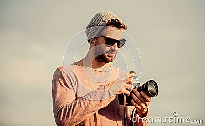 Manual settings. Guy photographer outdoors sky background. Hipster reporter taking photo. Photojournalist concept Stock Photo