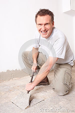 Manual worker disassembling old floor tiles Stock Photo