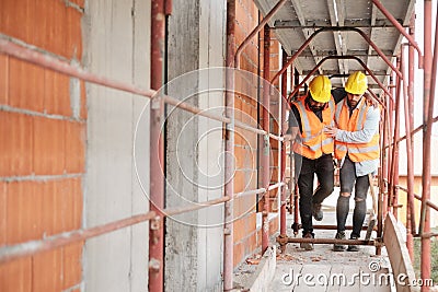 Manual Worker Helping Injured Colleague In Construction Site Stock Photo