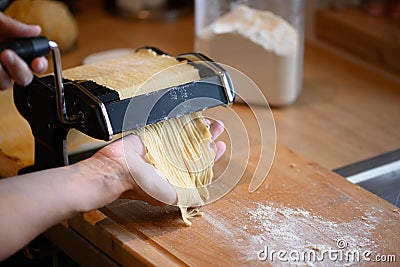 Manually selfmade noodles pasta with machine on wood Stock Photo