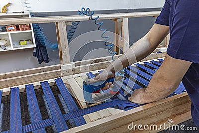 Male carpenter repairing wooden armchair in small business woodwork workshop Stock Photo