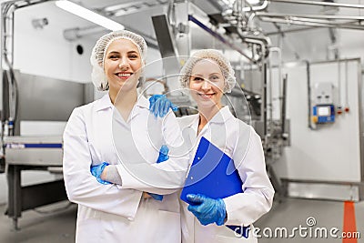 Happy women technologists at ice cream factory Stock Photo