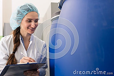 Manufacturing employee writing report during quality control in Stock Photo