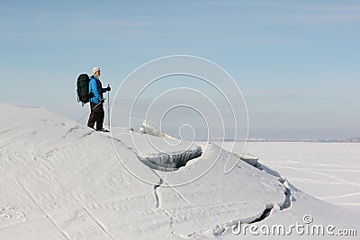 Manwith a backpack is skiing on theice of the frozen river Stock Photo