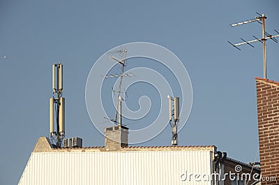 Many antennas on the roof of an urban house Stock Photo