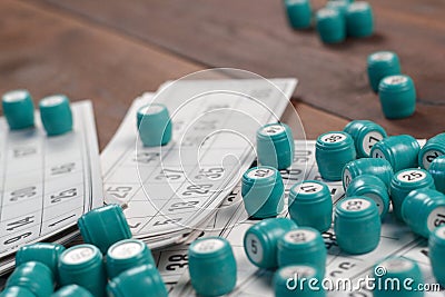 Many barrels with numbers and cards for lotto or russian bingo table game on wooden surface. Russian lotto has similar rules to Stock Photo