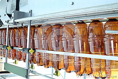 Many brown plastic bottles go on conveyor belt Stock Photo