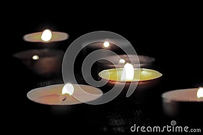 Many burning candles with shallow depth of field. The concept of mourn, grief or mourning. Stock Photo