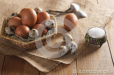 Many chicken and quail eggs, salt in saltshaker and two teaspoons. Stock Photo