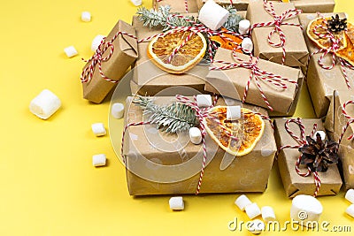 Many Christmas gift boxes on Illuminating yellow background. Wrapped craft paper New year diy Stock Photo