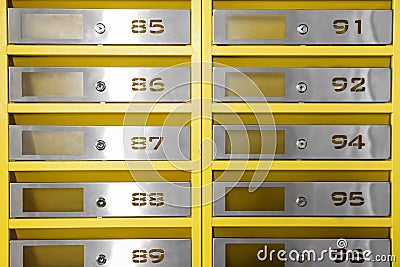 Many closed metal mailboxes with keyholes and numbers as background Stock Photo