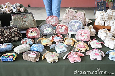 Many coin pouches with rabbit design and a few handbags with floral prints Editorial Stock Photo