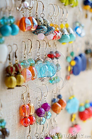 Many colorful earrings for sale at market Stock Photo