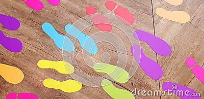 Many colorful footprint sticker on the wooden floor Stock Photo