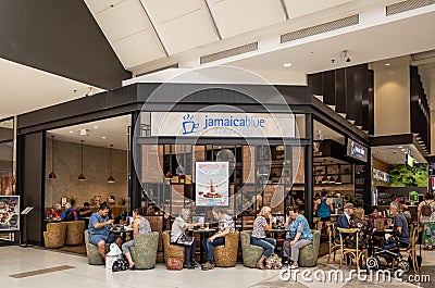 Many customers enjoy food and drinks in Jamaica Blue Cafe in the shopping centre Editorial Stock Photo