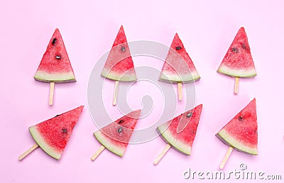 Many different bright ripe slices of watermelon on a stick on a bright pink background. Stock Photo