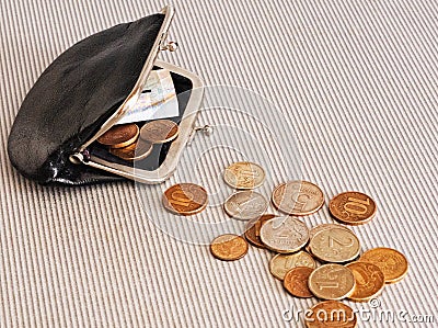 Many different coins from different countries from the black wallet are scattered around the table: dollars, pounds, rubles, penni Stock Photo