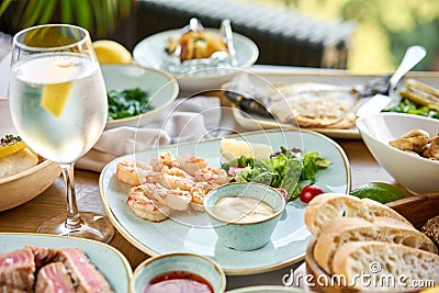 Many different delicious dishes dishes on the table. Various snacks and antipasti on the table. Plates seafood BBQ with Stock Photo