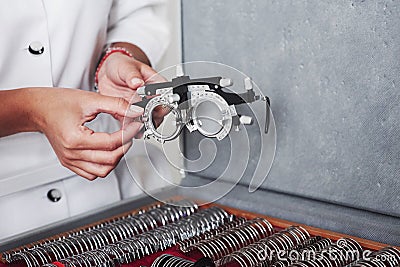 Many of different lenses below. Female hands holding the optical device for eye testing Stock Photo