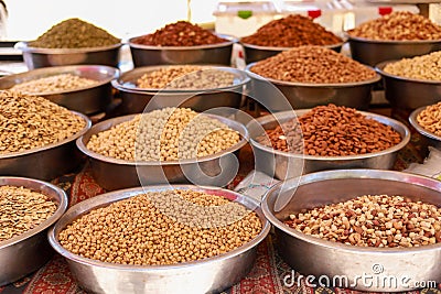 Many different nuts in large metal vices on the counter of a local bazaar Stock Photo