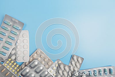 Many different packs of pills on a blue background. Copyspace Stock Photo