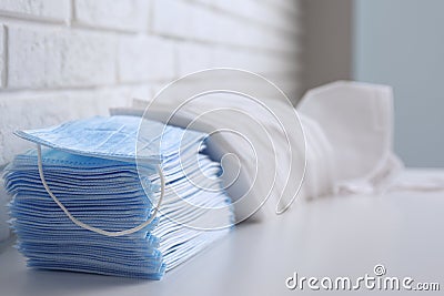 Many different respiratory masks on white table. Protective essentials during COVID-19 pandemic Stock Photo