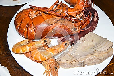 Many different seafood lobster shrimp octopus crabs dish lie on meze plates Stock Photo